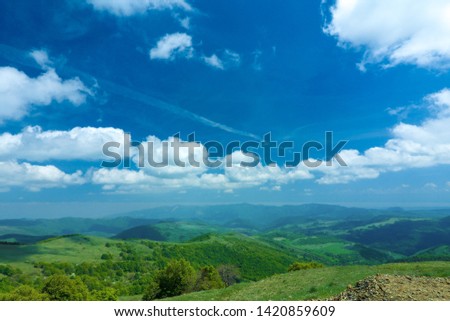 mountain landscape on a sunny day.
Green mountains with trees and sky with white clouds.