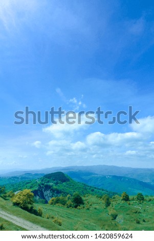 mountain landscape on a sunny day.
Green mountains with trees and sky with white clouds.