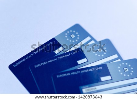 Stone, Staffordshire / United Kingdom - June 10 2019: Macro photo of three  European Health Insurance Cards. The EHIC Card from the NHS covers you against illness or injury when abroad. Royalty-Free Stock Photo #1420873643