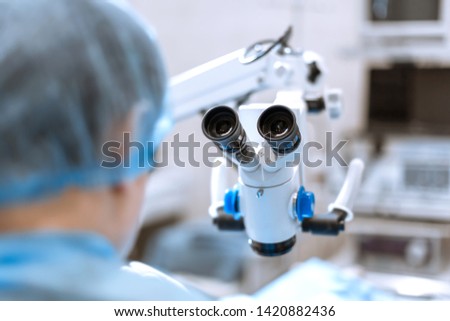 back of surgeon in front of surgical microscope prepare to hard operation. Royalty-Free Stock Photo #1420882436