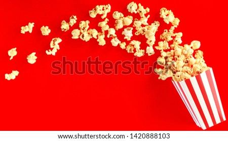 popcorn in square striped bucket on red background
