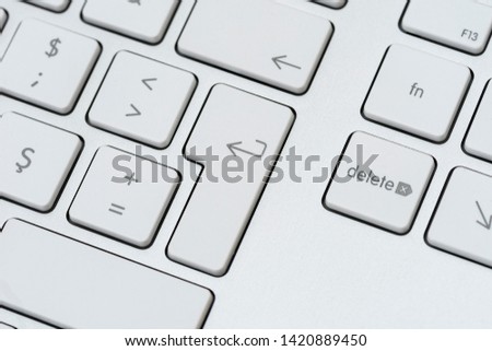 Grey computer keyboard with white buttons, selective focus