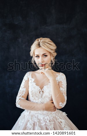 Studio portrait of a young girl of the bride with professional wedding makeup and hairdo.