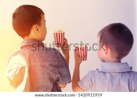 popcorn in paper cups in the hands of children