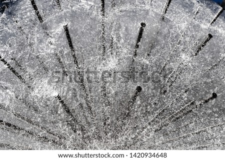 Water splashes from a metal circle fountain.