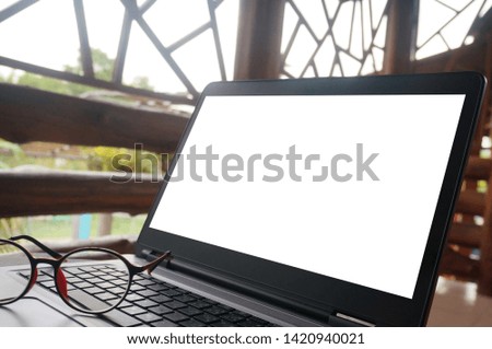 Laptop with blank screen on wooden table. Technology concept