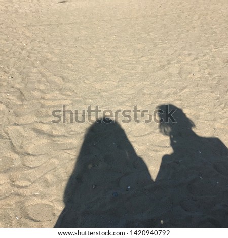 A friendly shadow with a friend in the sand