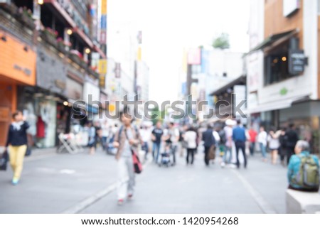 Blurred background, people walking, shopping at outdoor shady walking street market in the city. Summer Holiday shopping in Korea