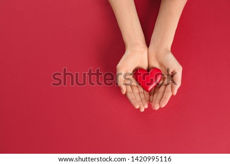 Woman holding decorative heart on color background, top view. Space for text