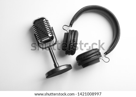 Retro microphone and headphones on white background, top view Royalty-Free Stock Photo #1421008997
