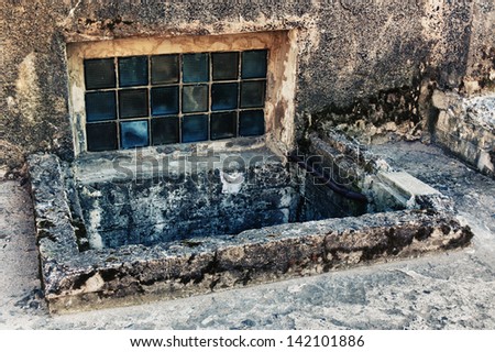 The window in the basement of an old house. Royalty-Free Stock Photo #142101886