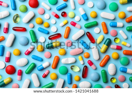 Different pills on color background, flat lay Royalty-Free Stock Photo #1421041688