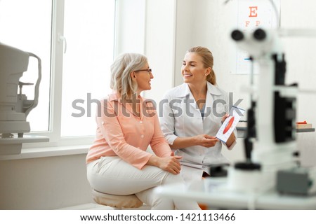 Important conversation. Beaming long-haired woman having appointment with older patient and discussing her issues Royalty-Free Stock Photo #1421113466