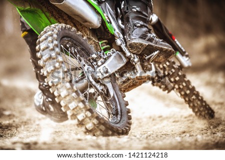 Detail of motocross wheel in heavy muddy terrain. Motocycle rider in action.