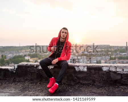 Manly but romantic sport man taking a smartphone or mobile phone photo or picture of sunset on a city rooftop after training