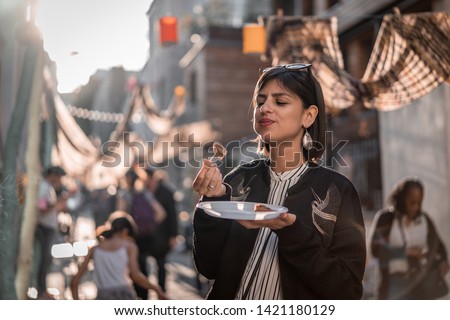 Beautiful young female tourist in city of Paris France enjoying holidays in beautiful little street festival eating street food Royalty-Free Stock Photo #1421180129