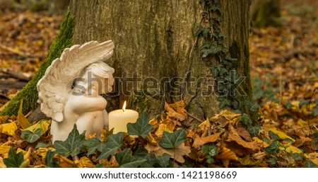 Angel with candle, nature cemetery. Moment of grief at the end of a life. Last farewell. Funeral concept. Royalty-Free Stock Photo #1421198669