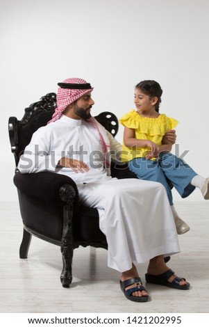 Father and daughter sitting on a couch. Royalty-Free Stock Photo #1421202995