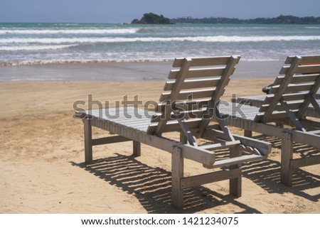 Beautiful Sri Lankan view of the Indian Ocean with sun loungers on the beach. Summer holidays in Asia. Stock photos