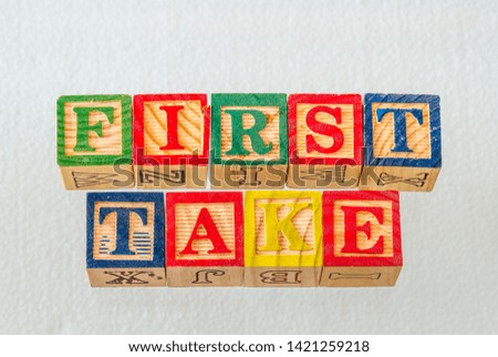The term first take visually displayed using colorful wooden blocks on a clear background image with copy space in landscape format