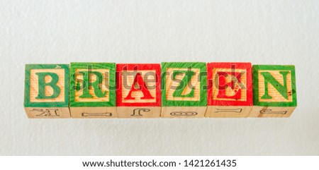 The term brazen visually displayed using colorful wooden blocks on a clear background image with copy space in landscape format