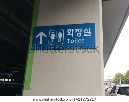 A toilet sign in parking lot.