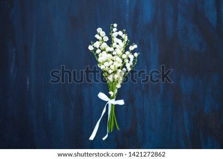 Wonderful fragrant white flowers with a delicate scent. Lily of the valley flowers on black wooden table