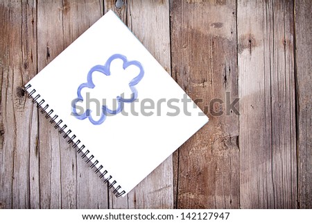 Painting of cloud on notebook or sketch book with paintbrush, close-up