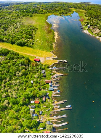 Aerial of coastal landscape with row of jetties lining the shore of a bay. Location Hasslo island in Blekinge archipelago, Sweden.