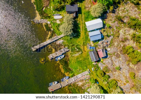 Aerial of a small fishing camp with sheds, boats and jetties. Location Hasslo island in Blekinge archipelago, Sweden.
