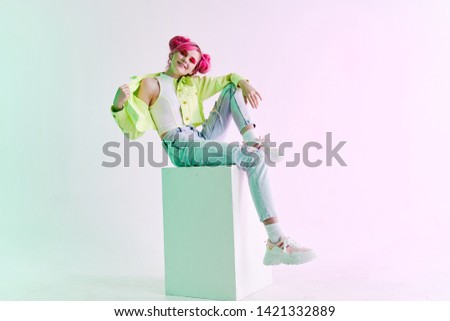 woman with pink hair sits on a cube fashion retro style