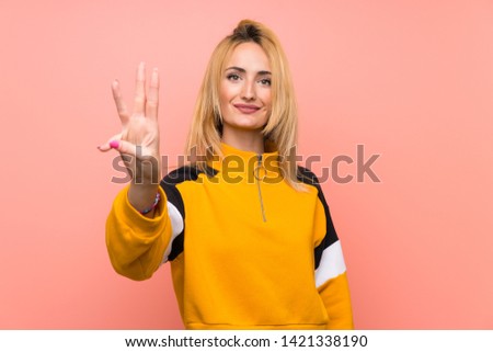 Young blonde woman over isolated pink background happy and counting three with fingers