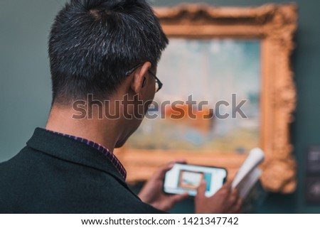 Man in museum using mobile phone Royalty-Free Stock Photo #1421347742