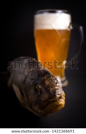 
Dried perch. On a black background with a glass of beer