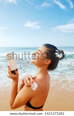 Woman applying sunscreen creme on  tanned  shoulder. Skincare. Body Sun protection suncream. Bikini hat woman applying moisturizing Suntan lotion on back.