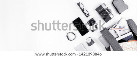 Creative top view flat lay of open backpack with laptop and tablet inside, mobile phone map copy space white background minimal style. Concept of modern man accessories for travel adventures and life Royalty-Free Stock Photo #1421393846
