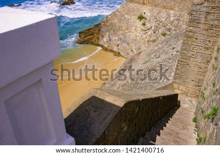 Stone stairs to the sandy beach. Atlantic seaside of Portugal.