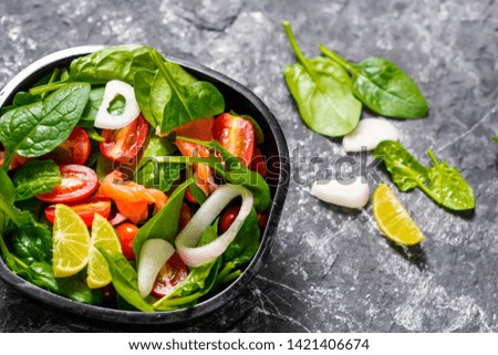 Selective focus Salmon Fresh green Salad with spinach, cherry tomatoes,baby spinach,  Concept for a tasty and healthy meal. Dark stone background. Top view. Close up.