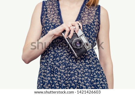Young woman holds a film camera in her hand.