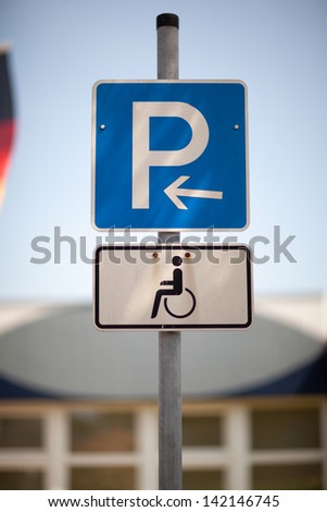 Parking for the disabled sign on a pole in an urban environment showing a parking place reserved for handicapped people only