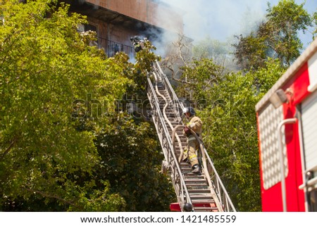 firefighters extinguish a fire in a high-rise residential building