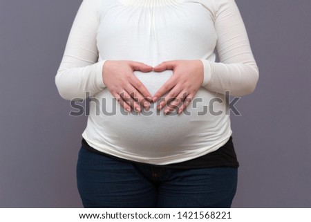 New excited Mother lovingly holding unborn child 