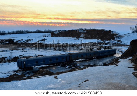 Sand mining in winter conditions in an industrial quarry. Conveyor Belt in mining quarry, Mining industry. Amazing winter sunset and shine in the mountains against the backdrop of snow and industry