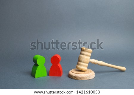 Two figures of people opponents stand near the judge's gavel. Conflict resolution in court, claimant and respondent. Court case, resolution and disputes settling disputes. The judicial system. Royalty-Free Stock Photo #1421610053
