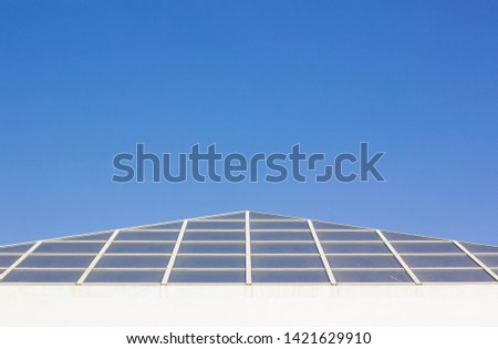 triangular glass dome modern architectural geometric shape of hotel reception building roof on blue sky background wallpaper pattern picture with empty space for copy or text