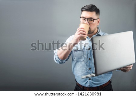 a mature man holding a computer and coffee