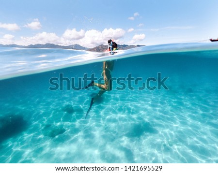 Snorkeling woman exploring beautiful ocean sealife. Water sport outdoor activities. Swimming and snorkeling on summer holidays. Under and above water photography. Royalty-Free Stock Photo #1421695529