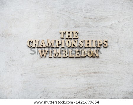 WIMBLEDON. Wooden, unpainted letters on a white table. Close-up, top view. Beautiful photo for invitation card