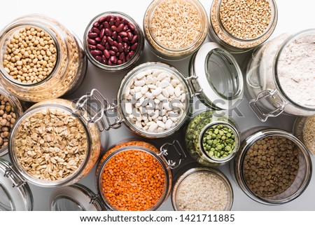 Variety of grains and legumes in glass jars, top view. Zero waste storage concept Royalty-Free Stock Photo #1421711885