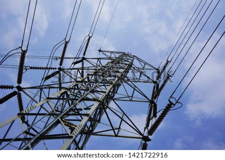 High voltage tower against blue sky and clouds background